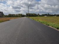 Zdjęcie przedstawia odcinek drogi po zakończonym remoncie